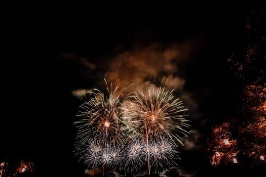 Group of people watching fireworks and using cellphones to record event. People capturing a fireworks shows with their mobile phone. Colorful fireworks celebration and the night sky background