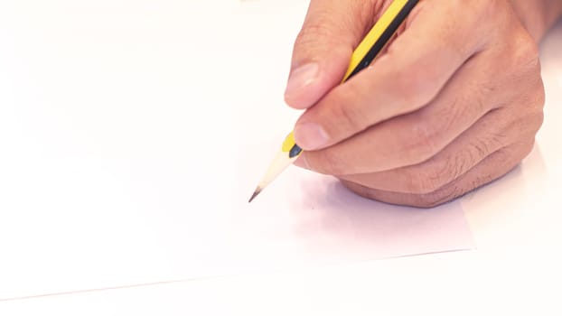 hand holding a pencil isolated on white background . Close Up on a man's hand writing on paper with a pencil. Planning business idea background . leave note or message concept.