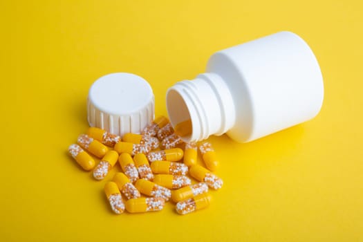 Yellow Pills with a white pill box on yellow background