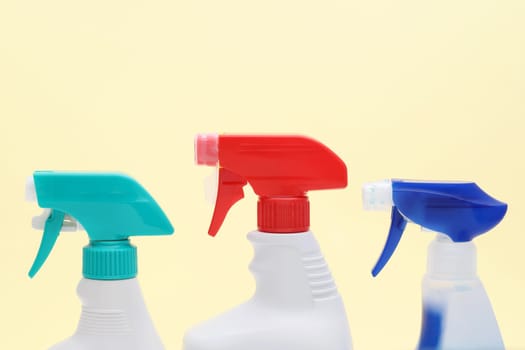 row of white plastic bottle with spray and foam nozzle on yellow background