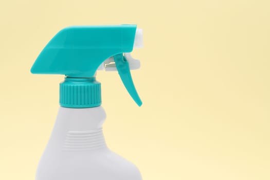 close up of white plastic bottle with spray and foam nozzle on pink background