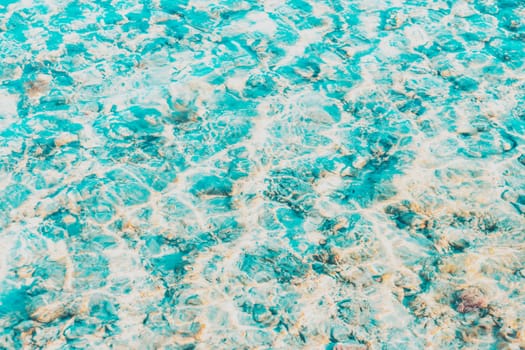 Vibrant blue white ripped water surface with clear transparent waves and nice sun sparkles over the reefs at Red sea or ocean. Conceptual abstract texture background. Travel or vacation summer concept