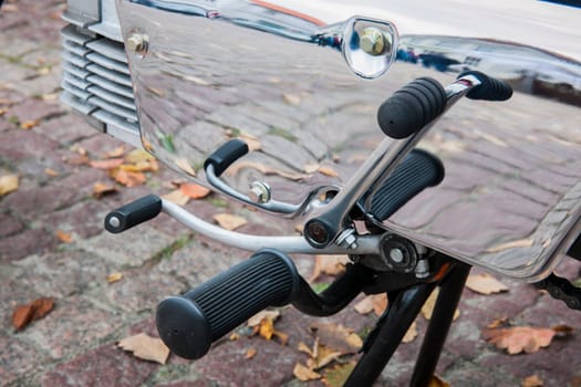 Detailed view of the gear shift, kick starter footrest and kick starter on the mirror-smooth polished gear cover of an old moped of German origin.