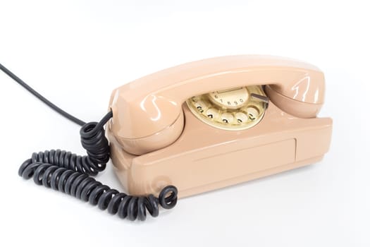 Oldschool pink telephone on a white background. Telecommunication. Vintage objects.