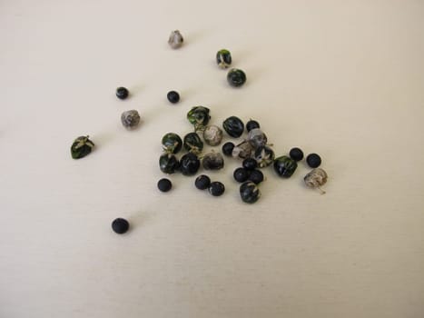Asparagus seeds, fruits and black seed pods on a wooden board