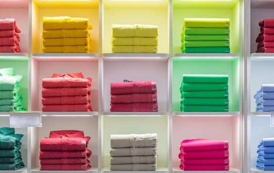 Polo t-shirt store interior. Shop shelves with  colored fashion cotton shirts.