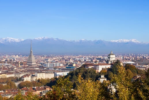 Turin, Italy - Circa November 2021: panorama with Alps and Mole Antonelliana,. Skyline of the symbol of Piedmont Region withi Monte dei Cappuccini - Cappuccini's Hill. Sunrise light.