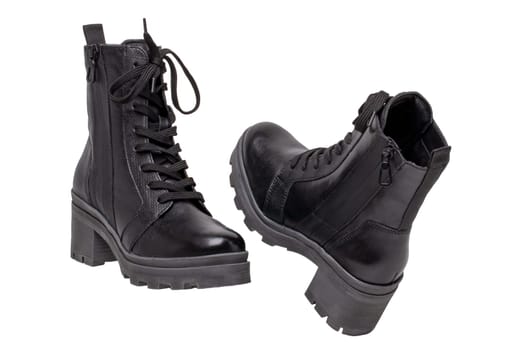 Womens boots and shoes. Closeup of female elegant black leather winter boots. Latest trends of winter shoe fashion for girls isolated on white background. Macro.