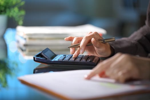 Executive hands calculating in the night at office