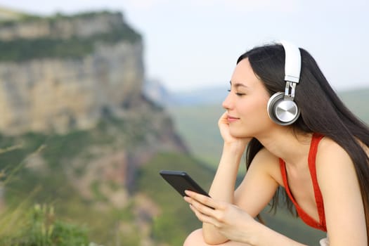 Asian woman listening to music relaxing outdoors