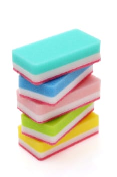Stacked color rectangular sponges for washing dishes and cleaning in kitchen on white background