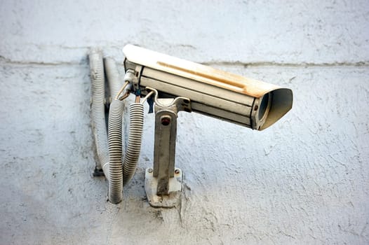 A security camera is hanging on a concrete post. High quality photo