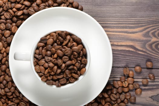 White coffee mug filled with coffee beans. High quality photo