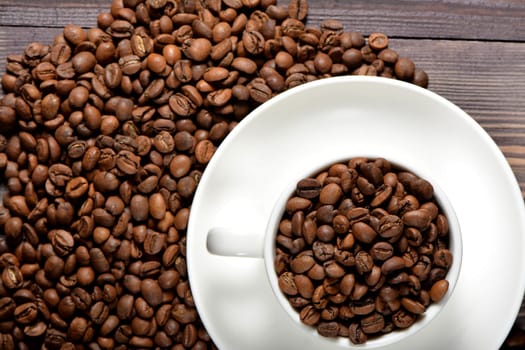 White coffee mug filled with coffee beans. High quality photo