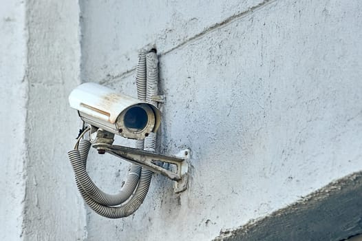 A security camera is hanging on a concrete post. High quality photo