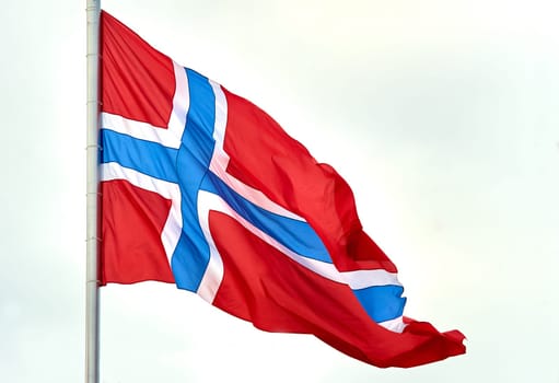 The flag of Norway hangs on the flagpole. High quality photo