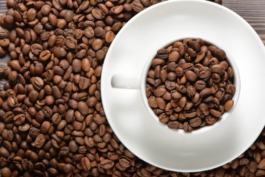 White coffee mug filled with coffee beans. High quality photo