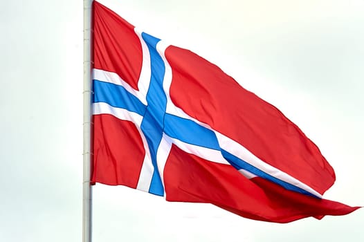 The flag of Norway hangs on the flagpole. High quality photo