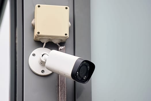 The surveillance camera is hanging on a metal profile. High quality photo