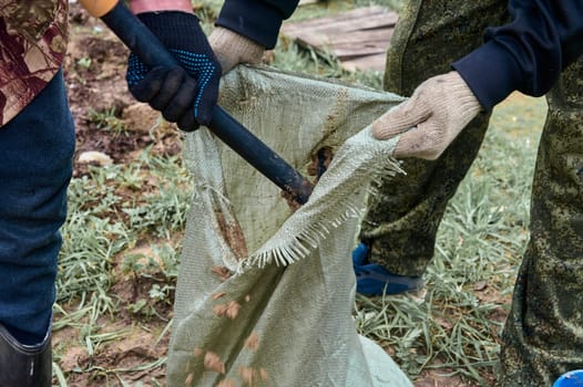 hands holding an open bag into which the earth is filled. High quality photo