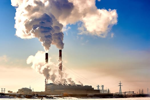 the chimneys of the CHP are smoking on a sunny winter day. High quality photo