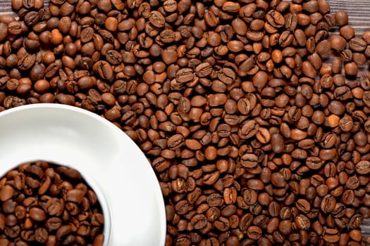 White coffee mug filled with coffee beans. High quality photo