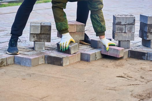 laying paving slabs on the sand with your hands. High quality photo