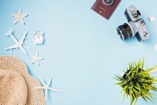 Flat lay top view mockup retro camera films, airplane, starfish, shells, hat traveler tropical accessories on a blue background with copy space, Business trip, and vacation summer travel concept