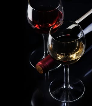 .Glass of red and white wine on black background