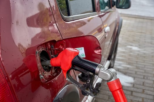 the gun is inserted into the gas tank of the car. High quality photo