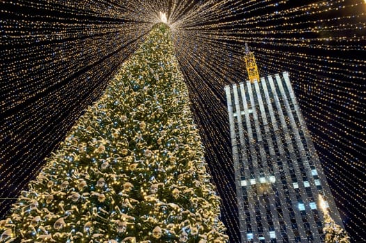 Christmas tree decorated with burning Christmas lights on the street. High quality photo