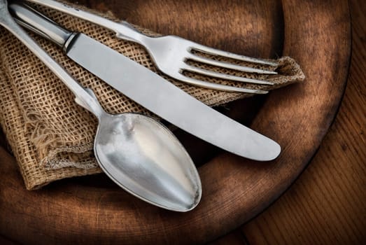 Vintage silverware on rustic wooden plate