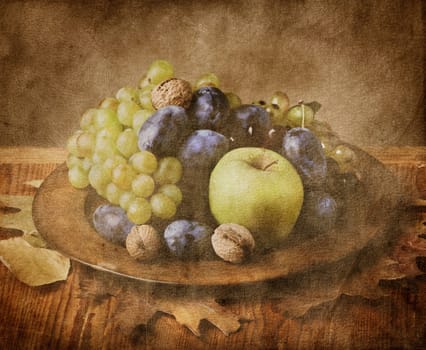 Autumn fruit in wooden plate on grungy background