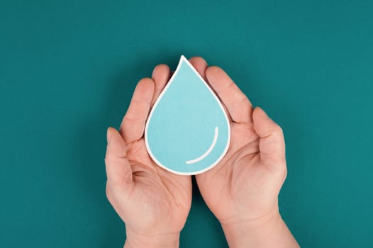 Hands holding a drop of water, paper cut out, environmental issue, copy space for text