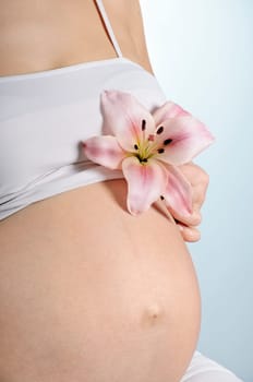 Image of pregnant woman belly with lily flower