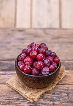 Red grape fruit in bowl isolated on wooden background