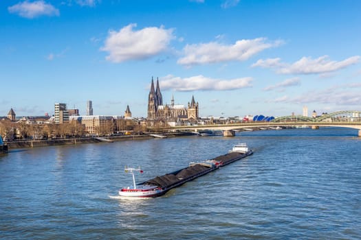 COLOGNE, GERMANY - FEB 12, 2014: Cologne skyline with cathedral  and ships on river Rhine, the central transportation route from north to south Germany