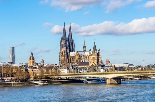 COLOGNE, GERMANY - FEB 12, 2014: Cologne skyline with cathedral  and ships on river Rhine, the central transportation route from north to south Germany