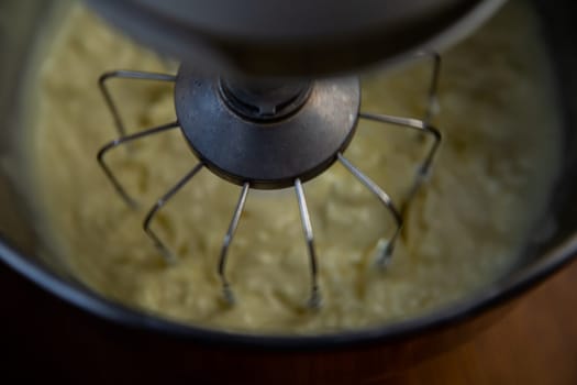 Metal mixer whips white cream, close-up photo. High quality photo