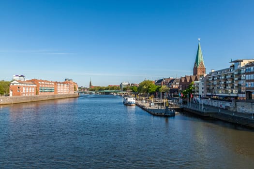 BREMEN, GERMANY - MAY 13, 2016: Cityscape with Teerhof on the left and view to the bridge at river Weser. The Weser is a main transportation route for Bremen.