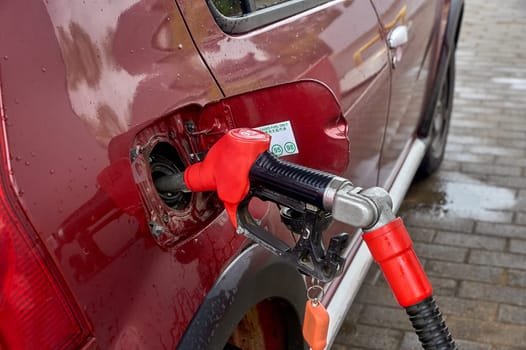 the gun is inserted into the gas tank of the car. High quality photo