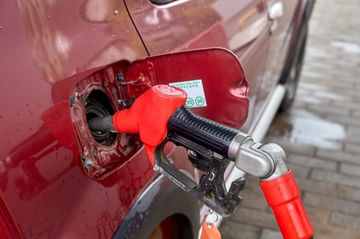 the gun is inserted into the gas tank of the car. High quality photo