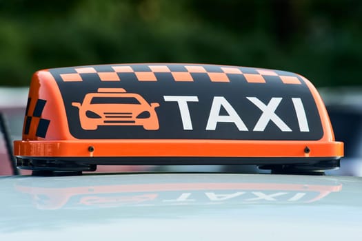 an orange taxi sign stands on the roof of the car. High quality photo