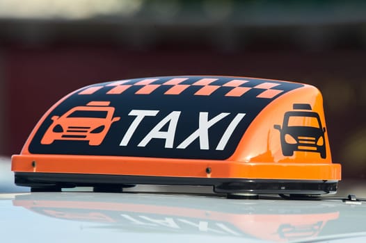 an orange taxi sign stands on the roof of the car. High quality photo