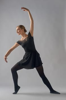 the dancer stands in a pose on a gray background. High quality photo