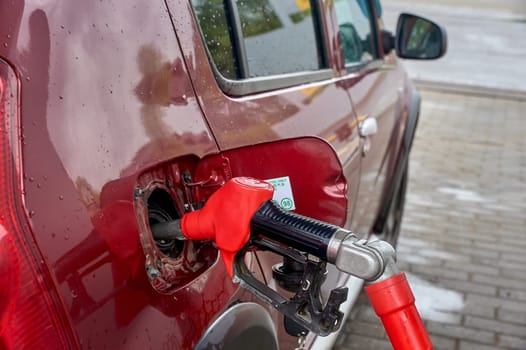 the gun is inserted into the gas tank of the car. High quality photo