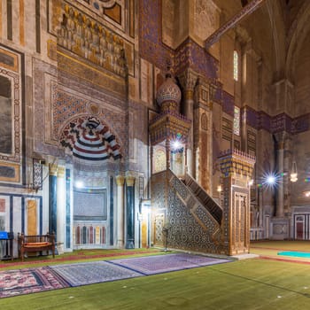 Colorful decorated marble wall with engraved Mihrab - niche - and wooden Minbar - Platform - at public historical Al Rifaii Mosque, aka Royal Mosque, Old Cairo, Egypt