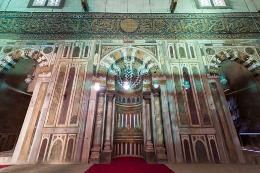 Mihrab of mausoleum chamber at Mamluk era historical Mosque and Madrasa of Sultan Hassan with multicolored marble mosaic, and carved inscription of the Throne Verse, Cairo, Egypt