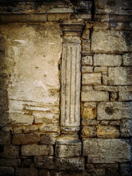 Ancient exterior wall with pillar and worn bricks as background.
