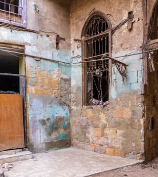 Day shot of old abandoned stone bricks wall with one grunge broken wrought iron window